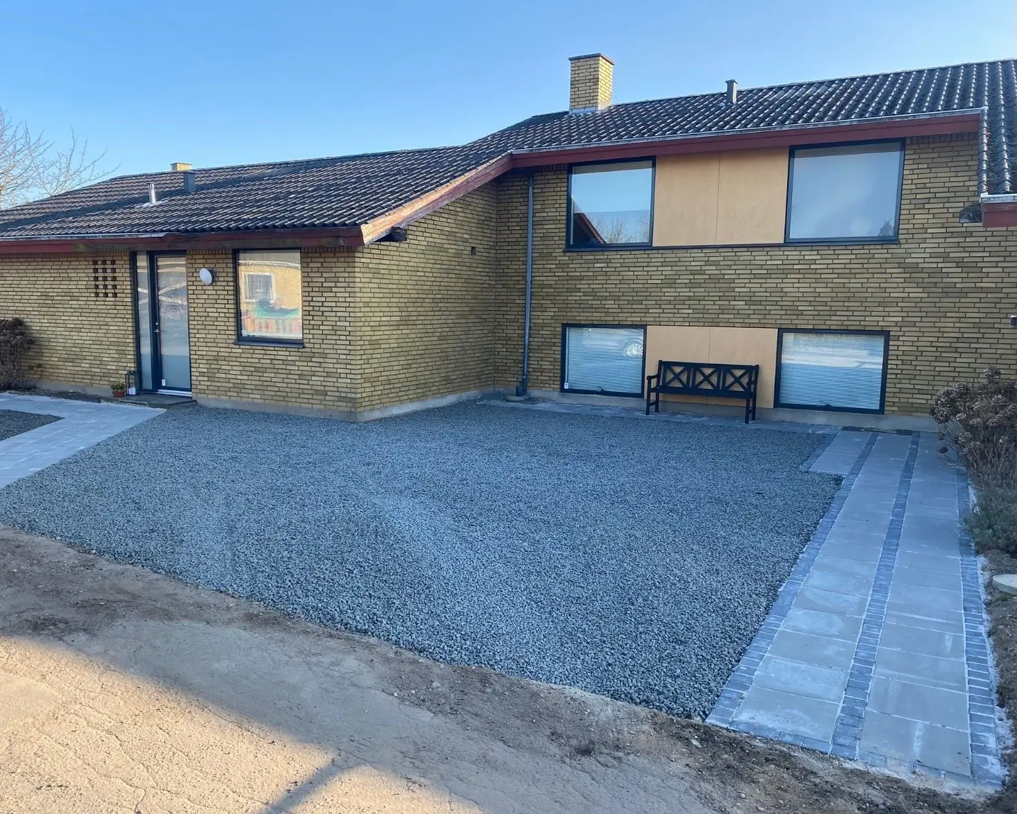 Grusindkørsel og flisesti ved et hus